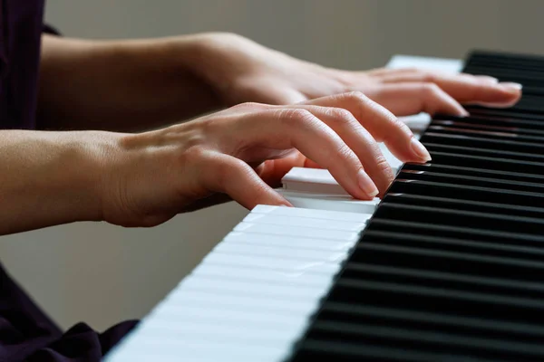 Jovem mulher tocando piano — Fotografia de Stock