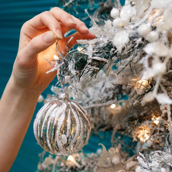 Händer dekorera julgran med en silver bollar. — Stockfoto