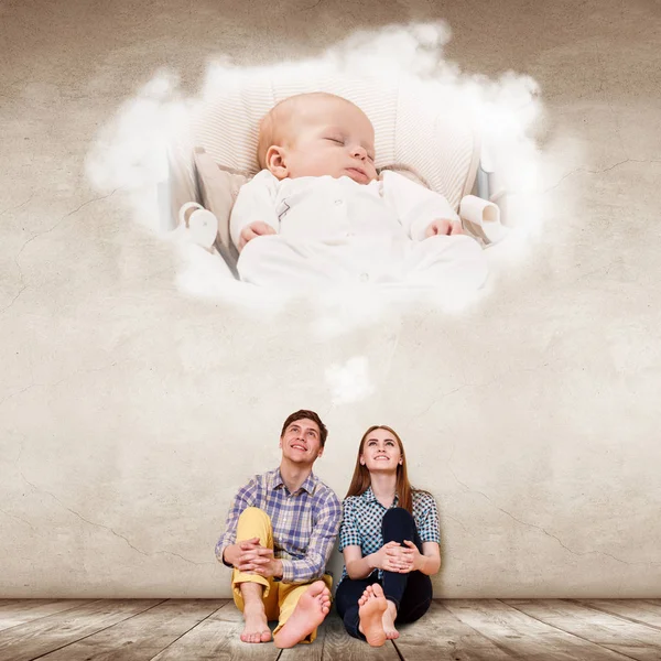 Young couple sitting on the floor and imagine their future baby. — Stock Photo, Image