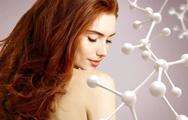 Hermosa mujer pelirroja cerca de gran estructura de molécula blanca . — Foto de Stock