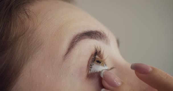 Молодая женщина закапывает глаза пипеткой . — стоковое видео