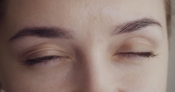 Close-up view on woman blinks and looks away. — Stok Video