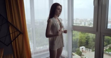 Redhead kadın evde beyaz bluz düğmeleri fustens.