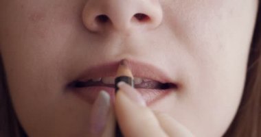 Genç kadın dudak kalemiyle dudaklarını boyadı.