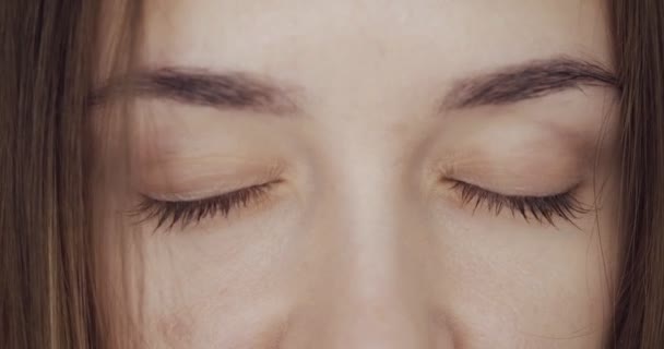 Close-up view on woman blinks and looks away. — Stock Video