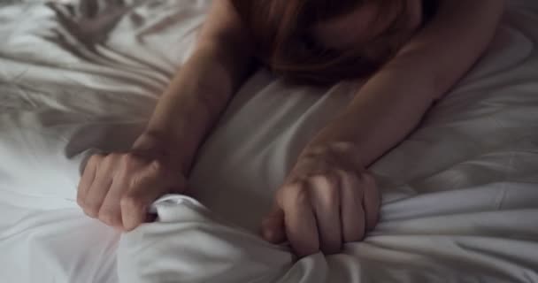 Vörös hajú nő félig meztelenül pózol feküdt az ágyban. — Stock videók