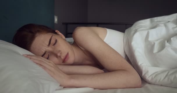 Mulher ruiva bonita despertando sem humor na cama acolhedora . — Vídeo de Stock
