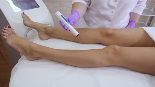 Especialista hace medidas de tono de piel en una mujer piernas . — Vídeos de Stock