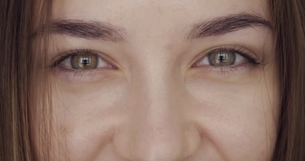Close-up weergave op dames ogen ziet en knikt op de camera. — Stockvideo
