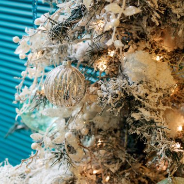 Beyaz oyuncaklar ve yapay kar ile Noel ağacı.