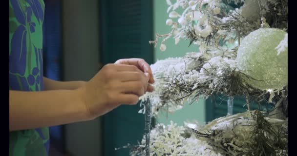 Mãos femininas decora árvore de Natal com brinquedos . — Vídeo de Stock