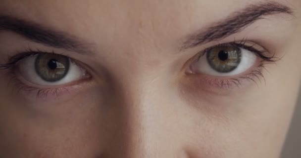 Close-up uitzicht op vrouw knippert en kijkt weg. — Stockvideo