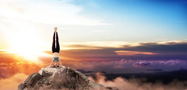 Ung kvinna utöva yoga på mountain peak klippa. — Stockfoto
