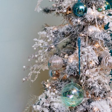 Beyaz oyuncaklar ve yapay kar ile Noel ağacı.