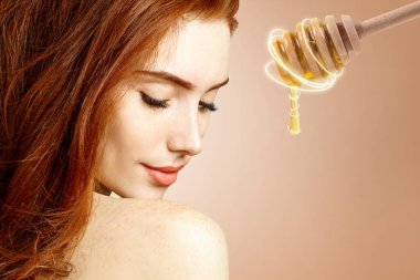 Genç kızıl saçlı kadın ve bal kaşığı maskeye hazırlan..