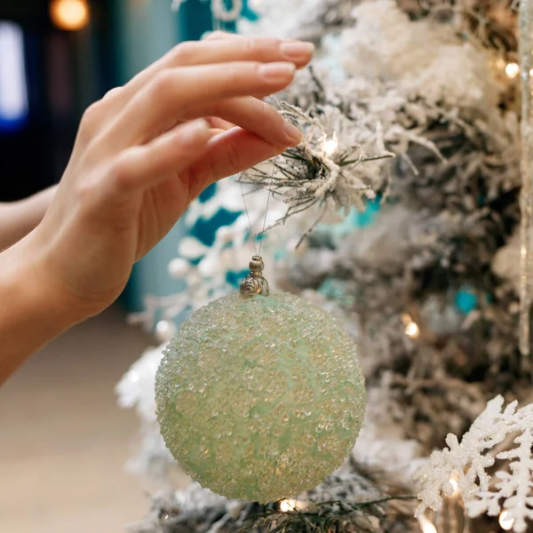 Händer dekorera julgran med en silver bollar. — Stockfoto