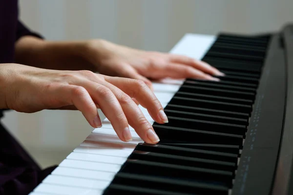 Jovem mulher tocando piano — Fotografia de Stock