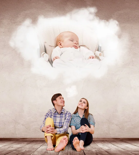 Jeune couple assis sur le sol et imaginer leur futur bébé . — Photo