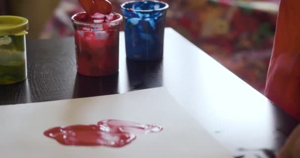 Щаслива маленька дівчинка з руками на малюнку червоної фарби — стокове відео