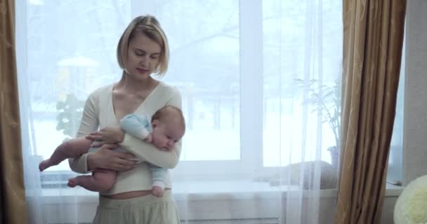 Young mother puts her little baby to sleep. — Stock Video