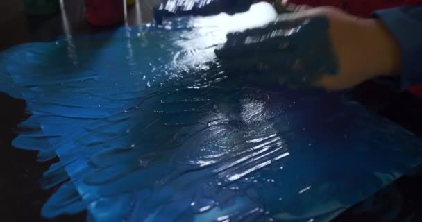 Menina feliz com as mãos no desenho de pintura azul — Vídeo de Stock
