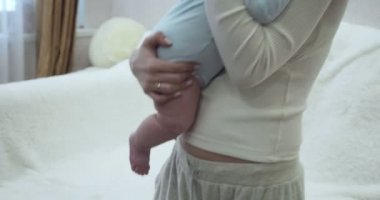 Yavrusunu kucağına alıp kucağına alan genç annenin ellerine bak..