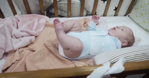 Piccolo bambino neonato carino si trova sulla schiena nella culla . — Video Stock