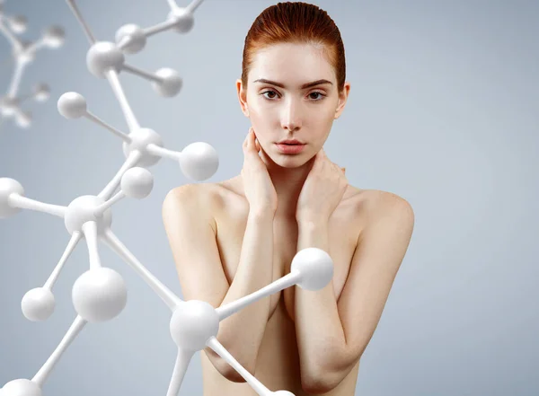 Young woman covering her breasts among molecules chain. — Stock Photo, Image
