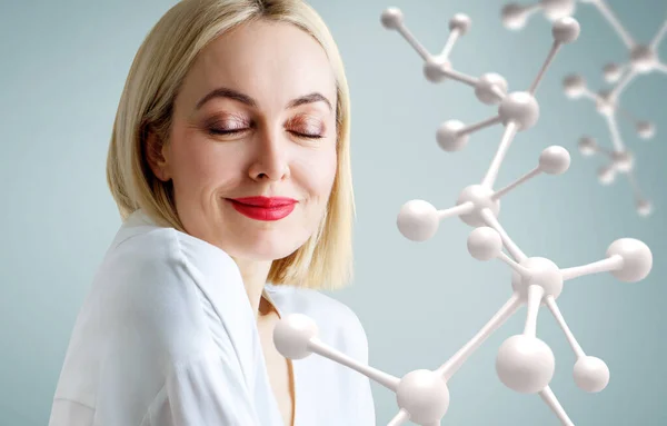 Belle femme adulte près de grande chaîne de molécules blanches. — Photo