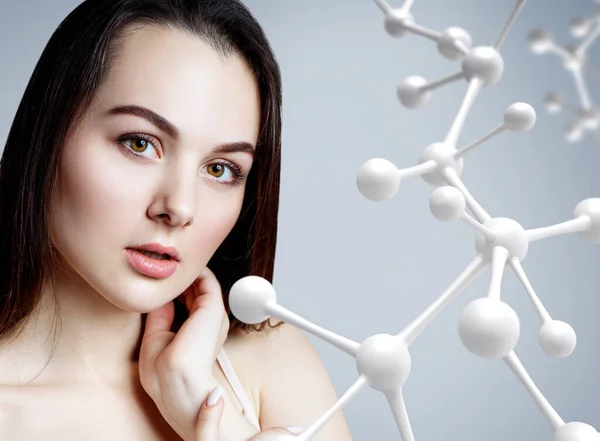 Beautiful woman near big white molecule chain. — Stock Photo, Image