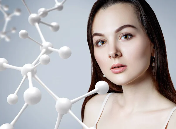 Hermosa mujer cerca de gran cadena de moléculas blancas. — Foto de Stock