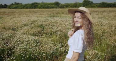 Kız papatya tarlasında yürüyor.