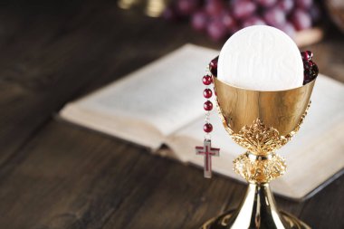 İlk komünyon tema. İncil'de, tespih ve altın chalice. Hıristiyanlığın ekmek ve üzüm sembolleri.