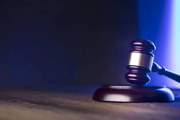 stock image Law theme. Mallet of the judge on wooden desk. Blue light. Place for text.