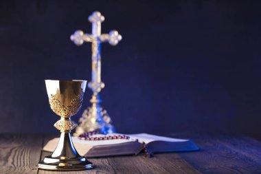 Roma Katolik Kilisesi tema. Çapraz, Holy Bible, tespih ve altın chalice kahverengi ahşap tablo.