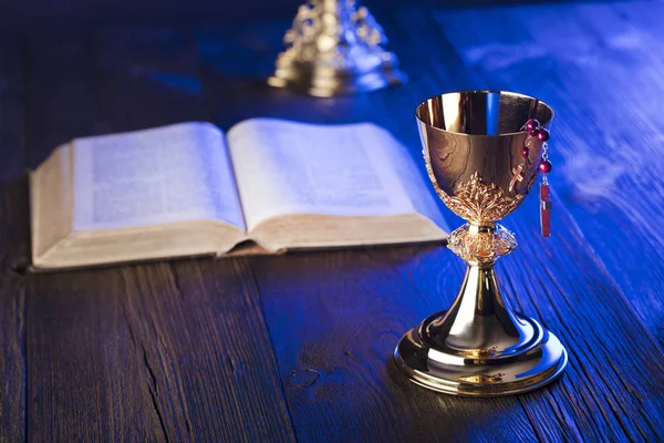 罗马天主教教堂的主题 圣洁圣经和金黄圣杯在褐色木桌 — 图库照片