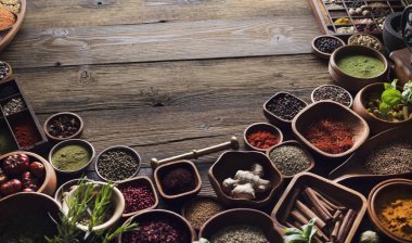 Baharat tema. Ahşap rustik masa üzerinde kase içinde baharatlar topluluğu. Metin veya tipografi için yer.