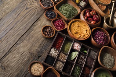 Baharat tema. Ahşap rustik masa üzerinde kase içinde baharatlar topluluğu. Metin veya tipografi için yer.