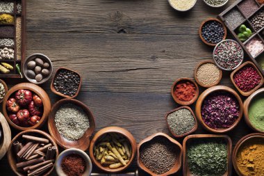 Baharat tema. Ahşap rustik masa üzerinde kase içinde baharatlar topluluğu. Metin veya tipografi için yer.