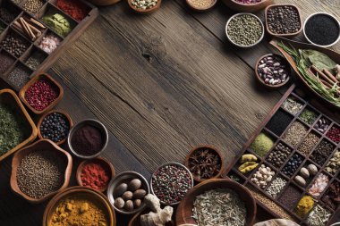 Baharat tema. Ahşap rustik masa üzerinde kase içinde baharatlar topluluğu. Metin veya tipografi için yer.