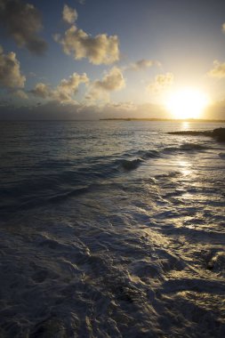 sea waves and beach on sunset background 