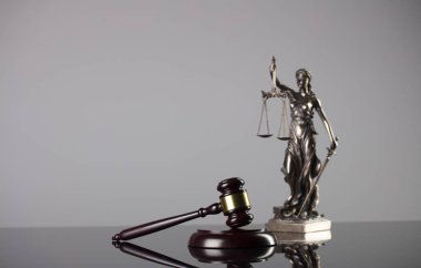 Hukuk Tema tokmak yargıç ve gri arka plan üzerinde adalet heykeli.