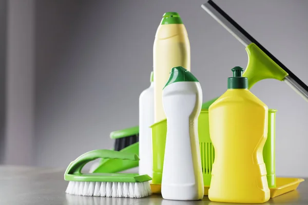 House and office cleaning up theme.  Set of colorful cleaning products on gray background. Place for logo, text or typography.