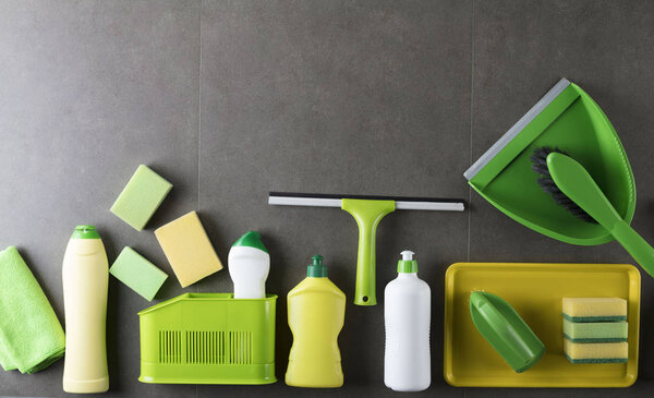 House and office cleaning up theme.  Set of colorful cleaning products on gray tiles.  background. Top view.  Place for logo, text or typography.
