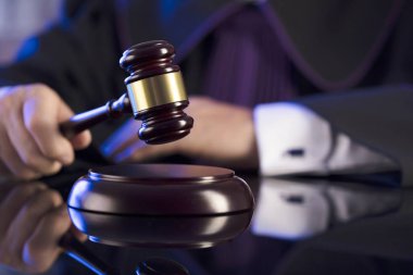 Mahkeme salonundaki yargıç. Erkek yargıç tokmağa vuruyor.