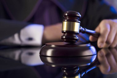 Mahkeme salonundaki yargıç. Erkek yargıç tokmağa vuruyor.