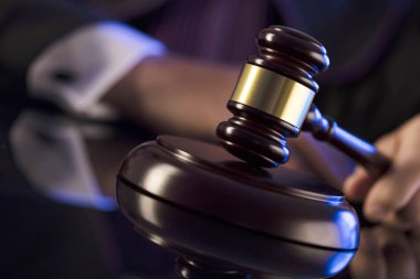 Mahkeme salonundaki yargıç. Erkek yargıç tokmağa vuruyor.