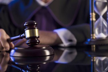 Mahkeme salonundaki yargıç. Erkek yargıç tokmağa vuruyor.