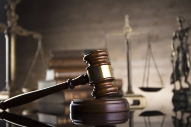 Mahkeme kavramı. Hukuk sembolleri kompozisyon. Tokmak, denge, adalet, kitaplar heykeli. Kahverengi zemin.