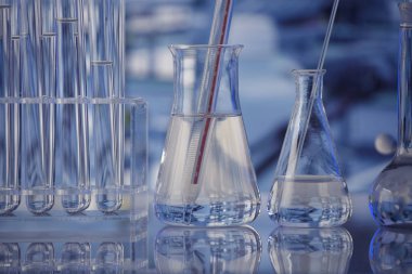 Laboratuvar konsepti. Mavi arka planda cam tüpler ve beherler.